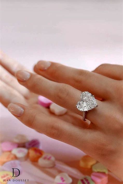 A Womans Hand Holding A Heart Shaped Diamond Ring