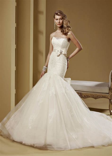 Frosted alençon lace appliqués on a tulle, soft mermaid with wide scalloped hemline and long, sheer petal train. Abiti da sposa a sirena 2015