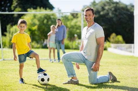 Padre E Hijo Jugando Al Fútbol En El Parque En Un Día Soleado Foto