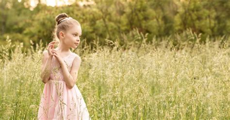Piękna Mała Dziewczynka W Białej Sukni Pozuje W Trawie Zdjęcie Stock Obraz złożonej z uczenie