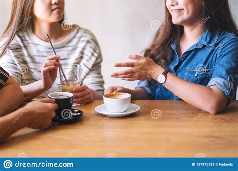 Friends Enjoyed Talking And Drinking Coffee Together In Cafe Stock