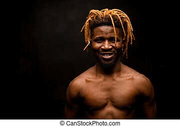 Black Guy With Blonde Dreadlocks Posing Holding It In The Dark Outfit