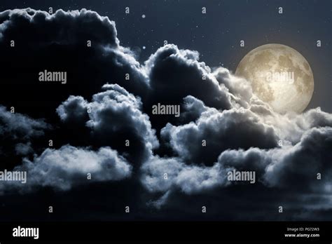 Full Moon Rises Behind Strong Clouds In A Clear Night Stock Photo Alamy