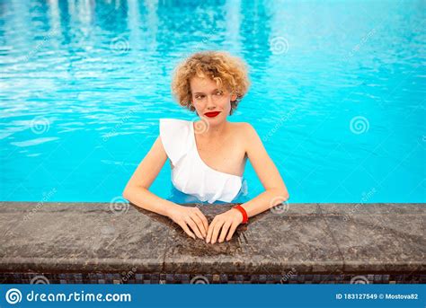 Beautiful Redhead Sitting By The Swimming Pool Stock Image Image Of