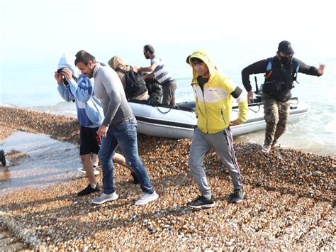 Migrants make off at speed as dinghy lands at Kent beach ...