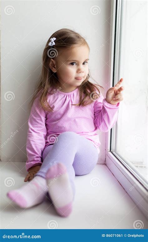 Cute Little Girl Sitting On The Windowsill Stock Image Image Of Young