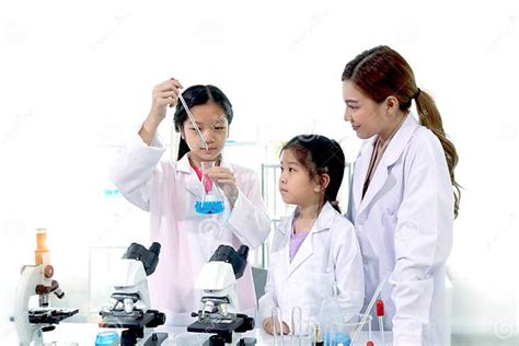 Students And Teacher In Lab Coat Have Fun Together While Learn Science