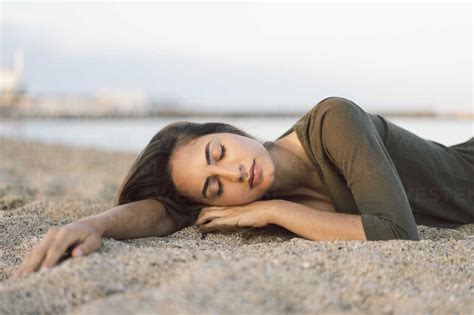 Beautiful Woman Relaxing On The Beach At Sunset Portrait Stock Photo