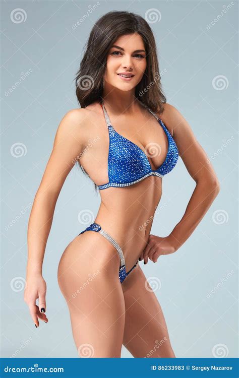 Donna Castana Sexy Del Culturista In Bikini Blu Immagine Stock