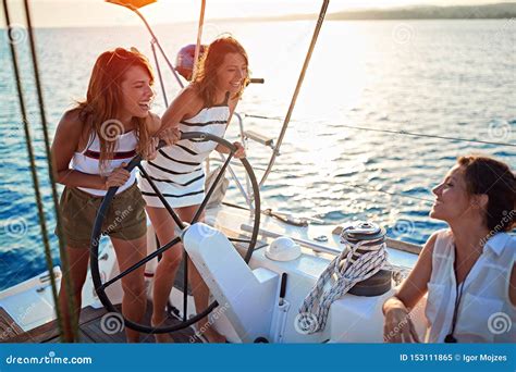 Young Girls Sailing On Boat Together And Enjoy At Sunset On Vacation