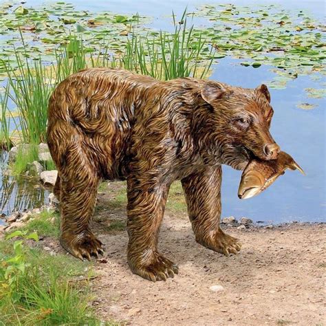A Statue Of A Bear Standing Next To A Body Of Water