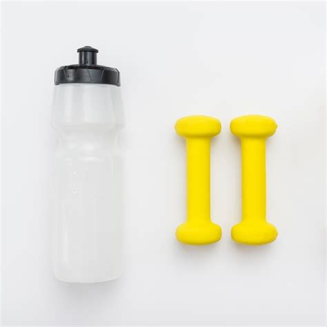 Free Photo Top View Of Yellow Weights And Water Bottle