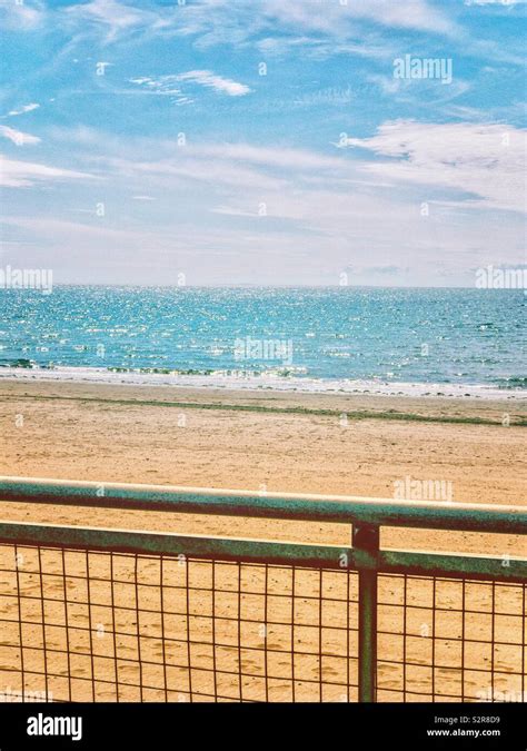 Mesh Railings On Seaside Promenade With Sandy Beach Blue Sea And Sky
