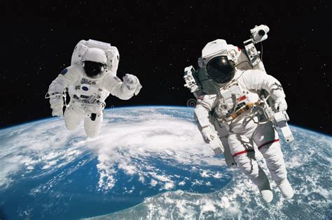 Two Astronauts Walking In Space With Earth Background Elements Of This