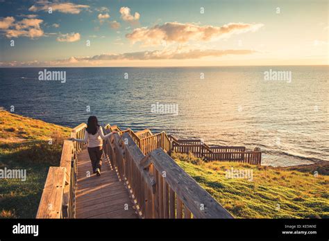 Woman Walking Down Hallett Cove Boardwalk To Enjoy Sunset From Beach