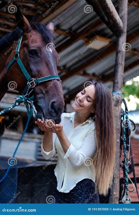 Beautiful Young Girl Looks After Her Horse In The Stable Stock Image
