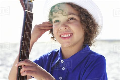 Mixed Race Boy Holding Guitar On Beach Stock Photo Dissolve