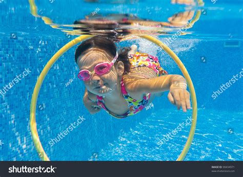Happy Smiling Underwater Child In Swimming Pool Little Girl Swims