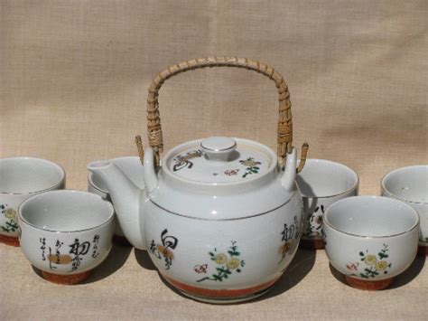 Meiji period, japanese kutani porcelain teapot and the sugar bowl with covers, finely hand painted in gold, red, black and green with beautiful various images of butterflies in foliate scrolls. Wicker handle pottery teapot and bowl cups, vintage Japan ...