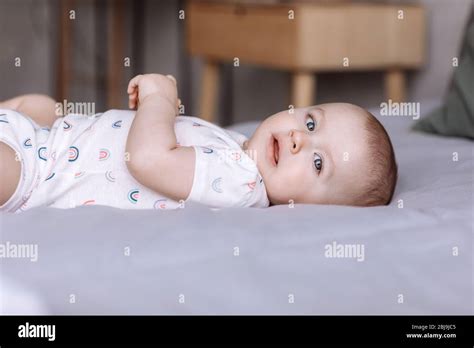 Portrait Of Cute Baby Little Girl Lies On Bed In The Bedroom At Home
