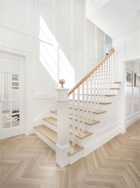 Herringbone Wood Floors In Foyer With White Painted Trim And Millwork