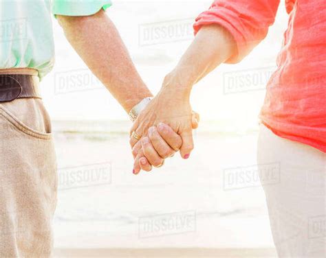 Couple Holding Hands On Beach Stock Photo Dissolve