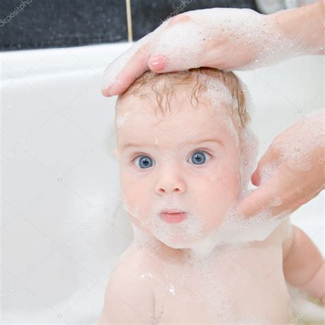 Until baby starts getting down and dirty on the ground, a daily bath isn't needed. Mother washing baby hair in bath. ⬇ Stock Photo, Image by ...