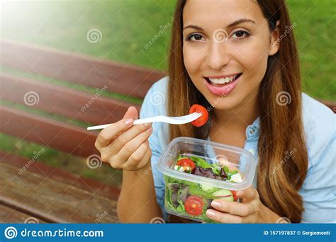 Young Woman Eating Salad On Lunch Break In City Park Living Healthy