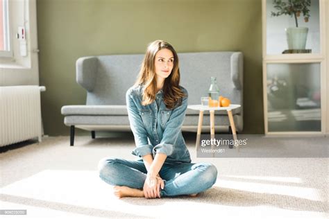Young Woman Sitting On The Floor In The Living Room High Res Stock