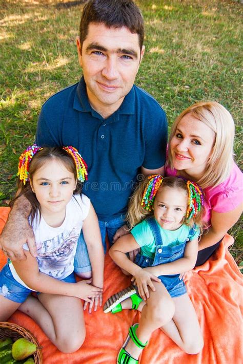 Feliz Familia De Dos Padres Con Dos Hijas En Una Cinta Naranja Foto De