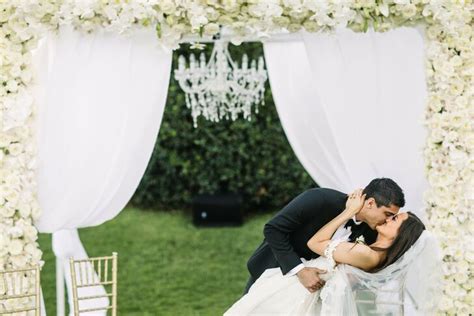 First Kiss Under White Flower Arch