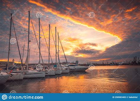 Scenic Sunset Over Luxury Yachts And Sailing Boats In Yacht Port
