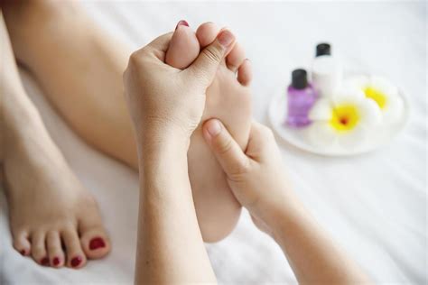 Woman Receiving Foot Massage Service From Masseuse Close Up At Hand And