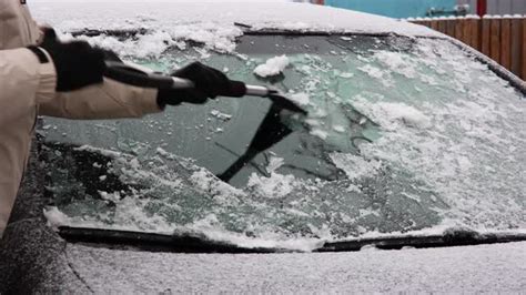 Man Scraping Ice Off Frozen Windshield Of A Car During Winter Stock
