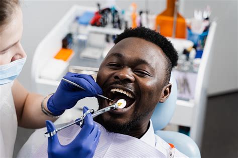 El Dentista Inyecta Una Jeringa Con Anestesia En La Boca Del Hombre