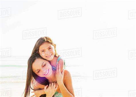 Portrait Of Smiling Girl With Her Mom On Beach Stock Photo