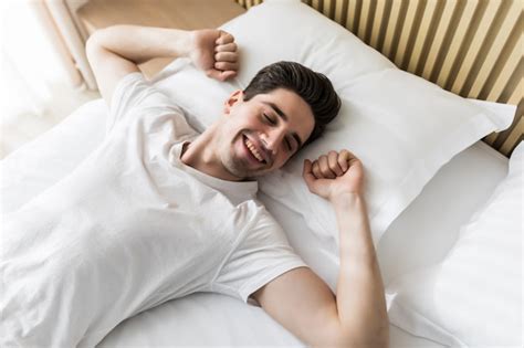 Premium Photo Young Handsome Happy Man Waking Up On Bed Top View
