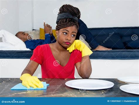 frustrated african american woman cleaning room with lazy man stock image image of black
