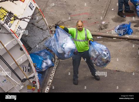 A Sanitation Worker in New York City throwing blue colored trash bags