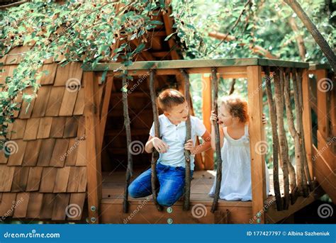 Little Boy And Girl Playing In Treehouse At Forest Park Active Kids On