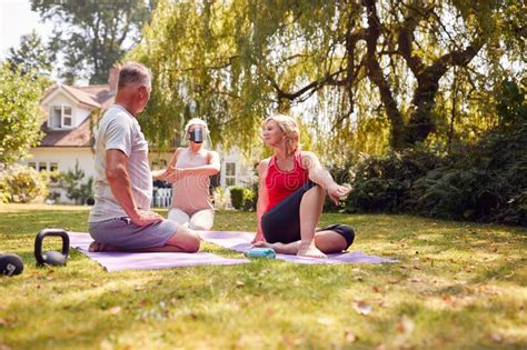 Senior Couple Taking Part In Private Socially Distanced Yoga Class With