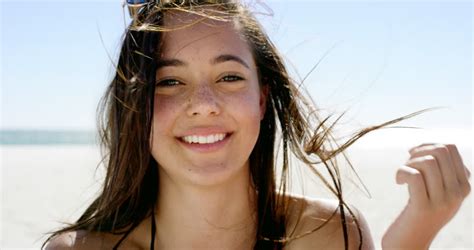 Close Up Portrait Of Beautiful Young Woman Running Hand Through Hair Blowing In Wind On Tropical