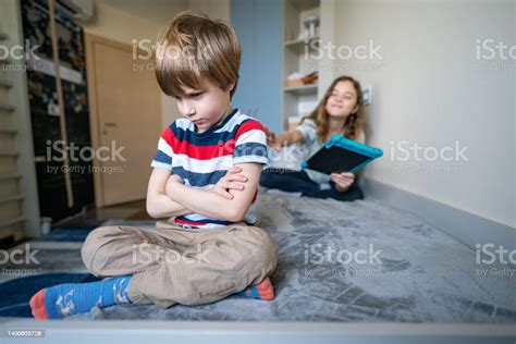 Trauriger Junge Der Auf Dem Bett Sitzt Während Ihre Schwester Versucht