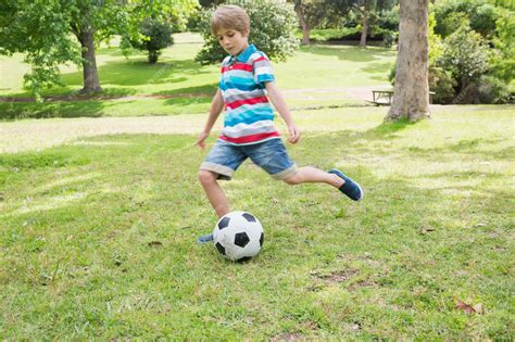 Premium Photo Full Length Of A Boy Kicking Ball At Park