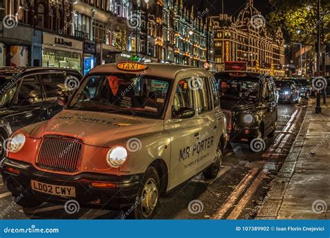 Night View With Typical London Taxis On Moving In Front Of Harrods