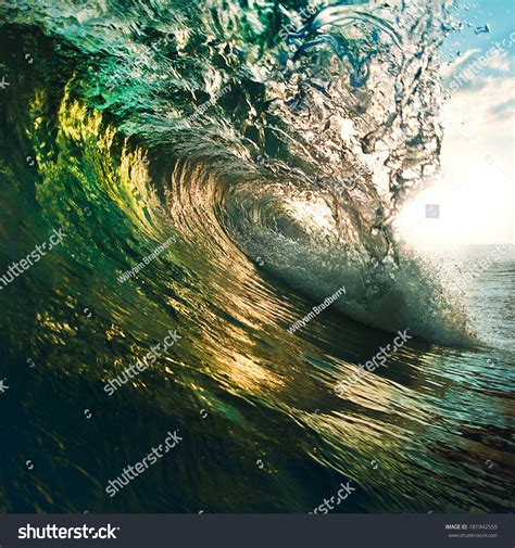 Colorful Ocean Wave Breaking At Sunset Stock Photo