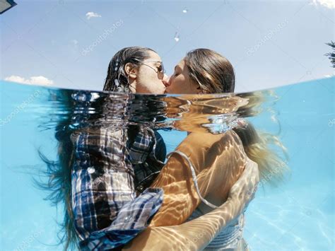 Two Lesbian Women Having Fun In Swimming Pool One Summer Afternoon