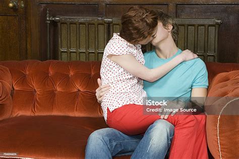 Teenagers Kissing On A Sofa Foto Stok Unduh Gambar Sekarang Sofa