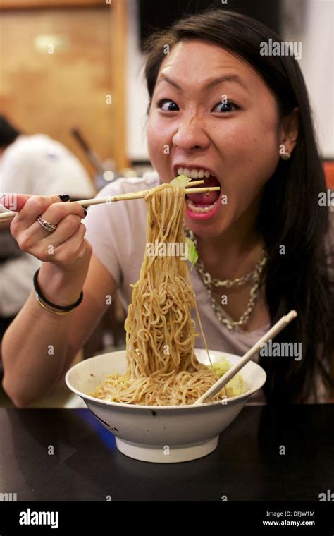 junge asiatische mädchen essen chinesisches nudelgericht in einem restaurant in chinatown