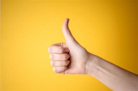 Emale Hand Showing Thumbs Up Gesture Premium Photo